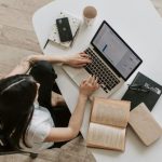 Home Network - Young lady typing on keyboard of laptop in living room