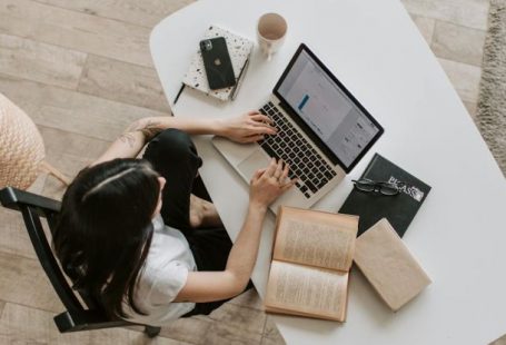 Home Network - Young lady typing on keyboard of laptop in living room