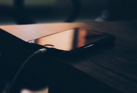 Charging - Shallow Focus Photography of Black Iphone 7 on Brown Wooden Table