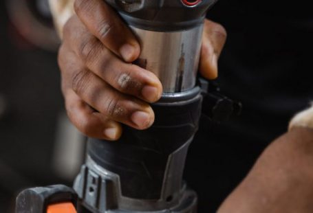 Routers - A Person Using a Compact Router on Wood