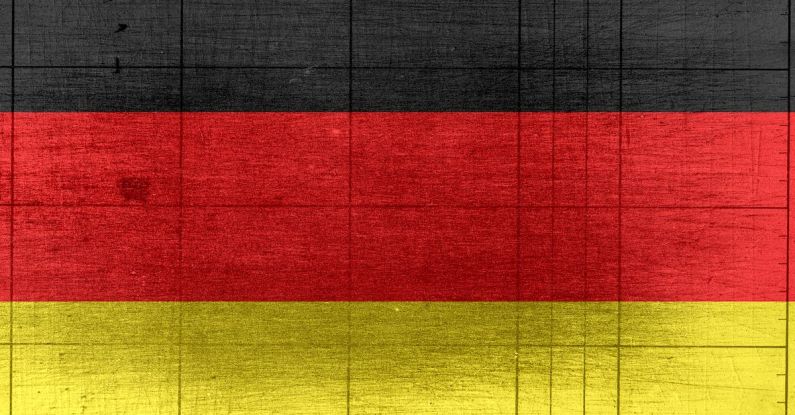 E-textiles - Grungy background designed as flag of Germany on shabby wooden board with measure scale